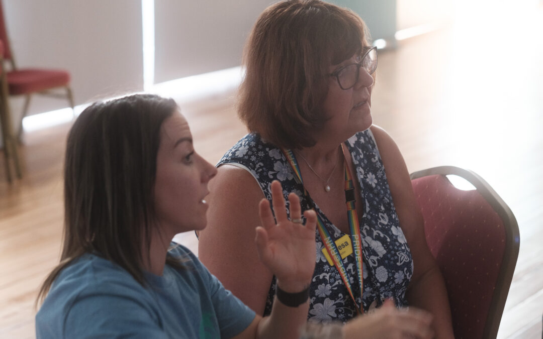 Two women sit together in a Dance for Neurology session run by CoDa Dance